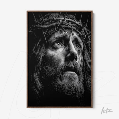 framed wall art in black and white depicting a male face with a crown of thorns in a light wood frame
