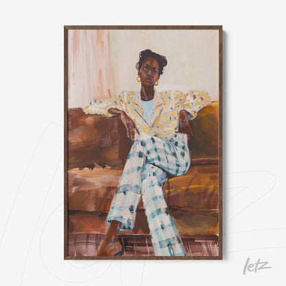 framed portrait of a seated woman on a sofa, wearing a floral yellow blazer and blue and white checkered pants with a light wood frame