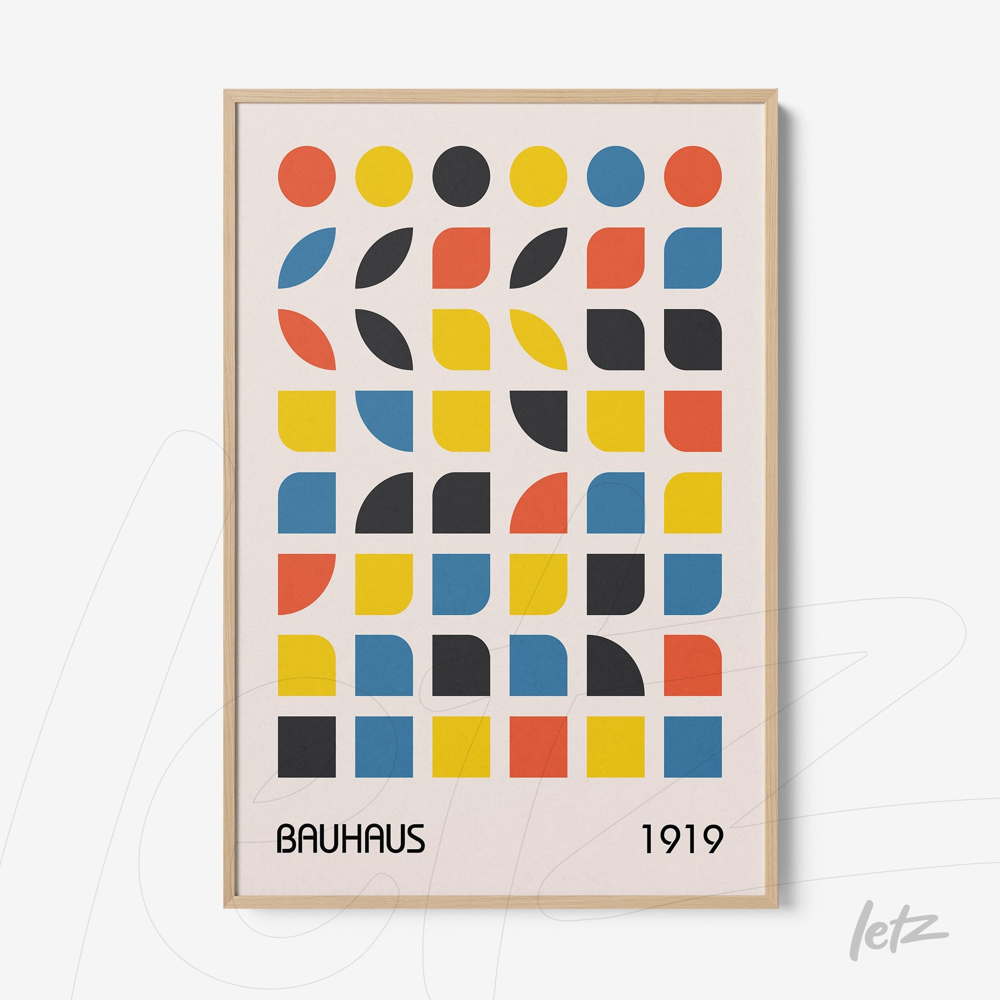 print featuring colorful geometric shapes in bauhaus style framed in light wood