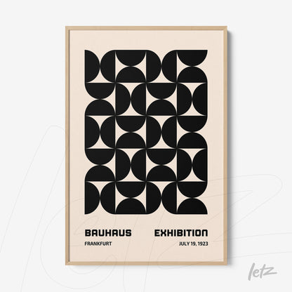 poster with black and white geometric art in a light wood frame, featuring text about the Bauhaus exhibition in 1923