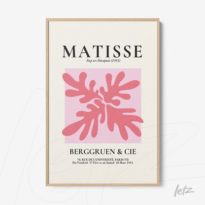 modernist wall art featuring pink and red shapes with light wood frame and soft pink background