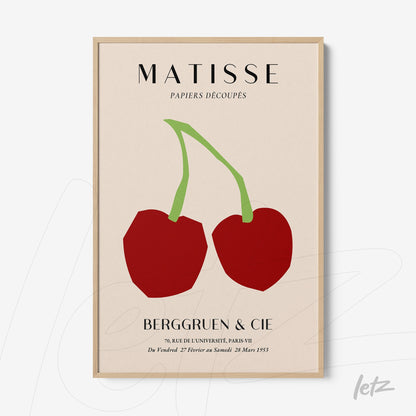framed wall art featuring modern illustration of two red cherries on a light background with a light wood frame