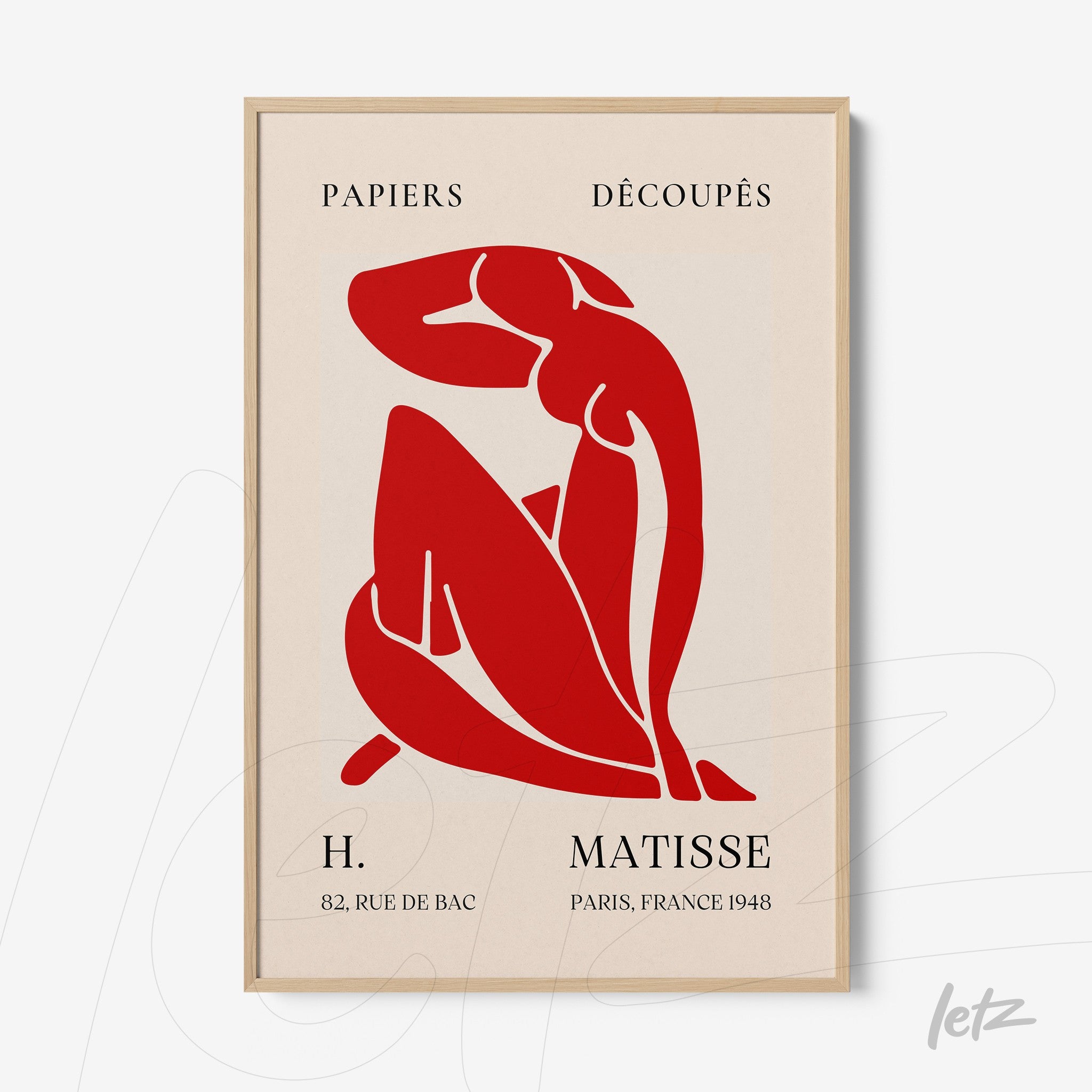 framed wall art featuring a stylized red figure of a woman on a light background with a light wood frame