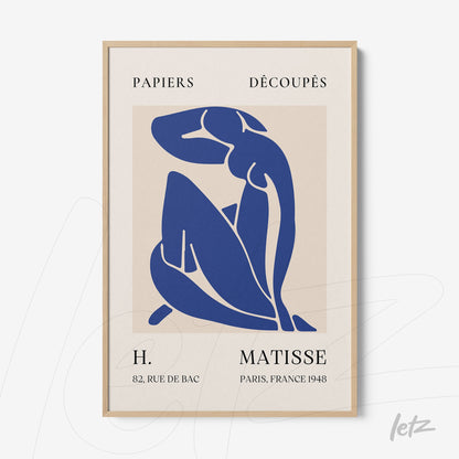 framed artwork featuring a stylized blue silhouette of a nude female figure with a light wood frame