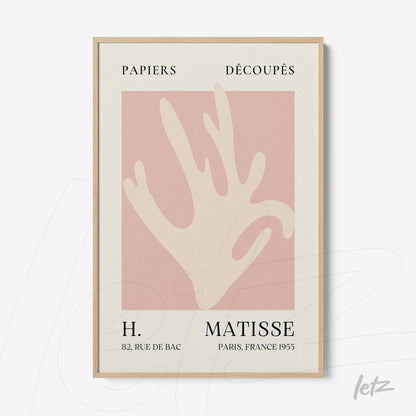framed wall art featuring a modern hand silhouette against a pink background with light wood frame