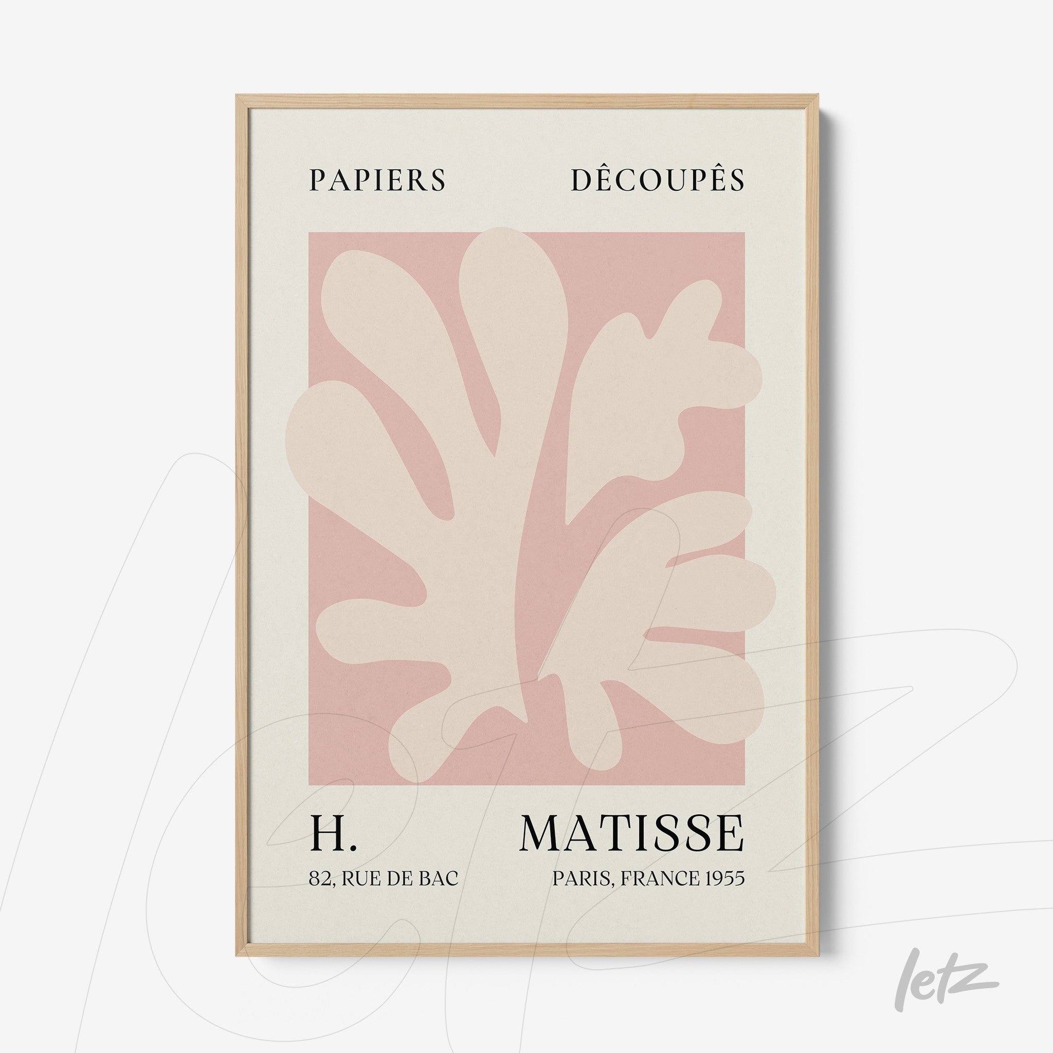 minimalist framed art featuring paper cutouts in soft coral colors with light wood frame