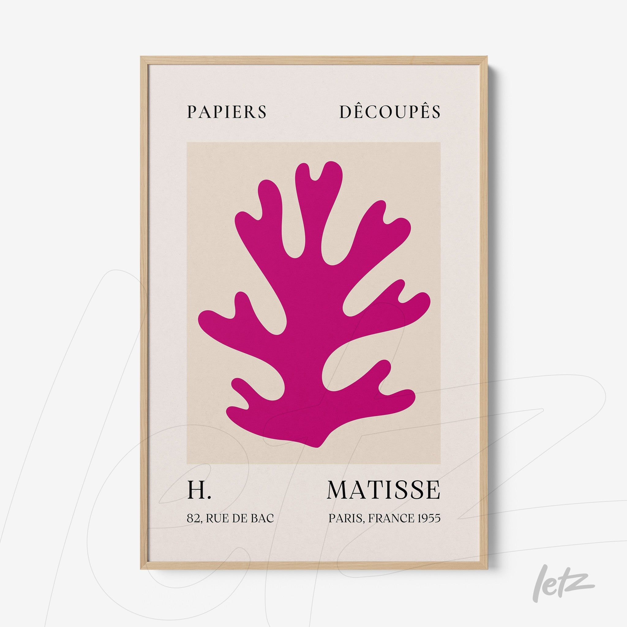 decorative art print featuring colorful cutouts in pink against a light background, framed in light wood