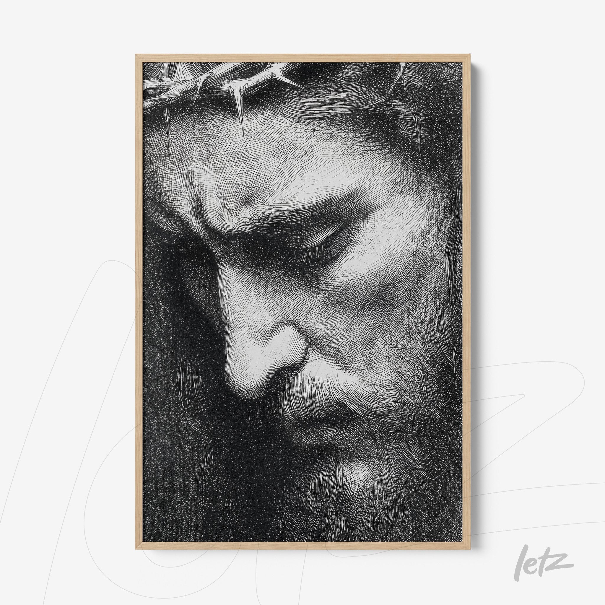 framed artwork depicting a serene man with a crown of thorns in light wood frame