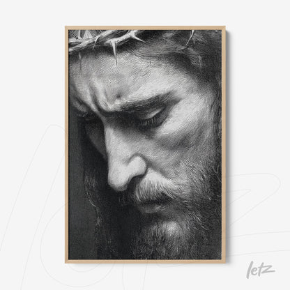 framed artwork depicting a serene man with a crown of thorns in light wood frame