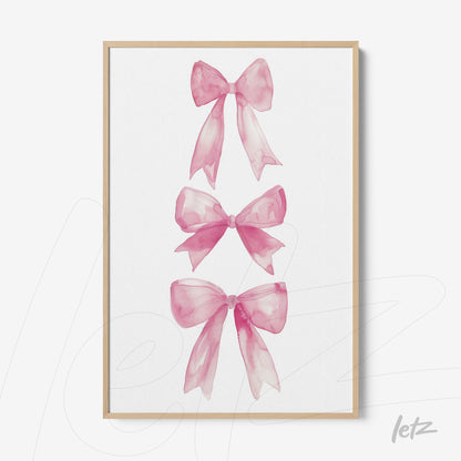 framed wall art featuring watercolor pink bows in a light wooden frame
