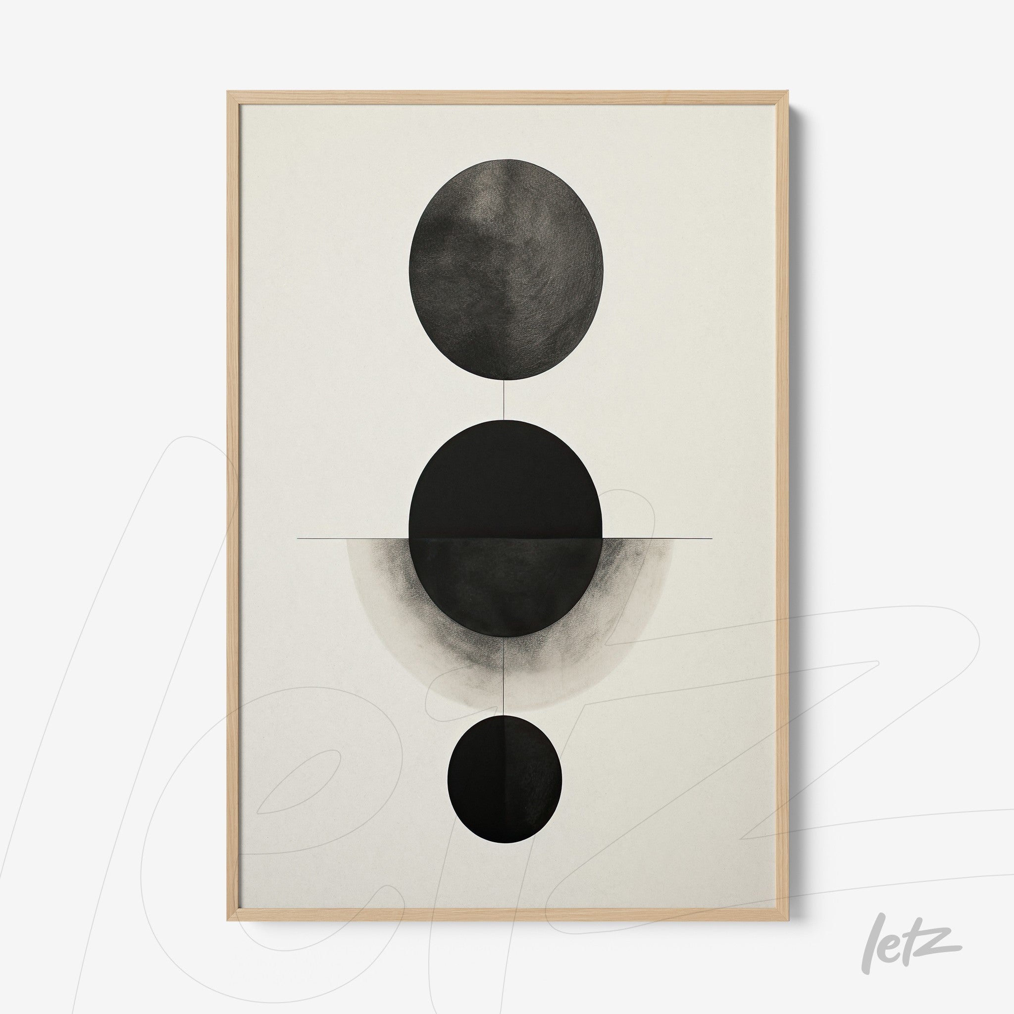 abstract wall art featuring black and white circular shapes on light background in light wood frame