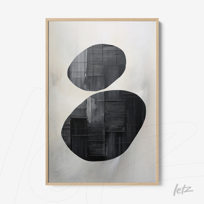 abstract wall art featuring black oval shapes on a light background with a light wood frame