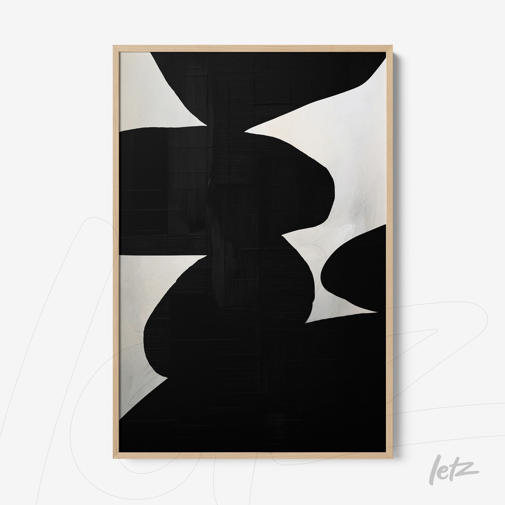 abstract wall art in black and white displayed in a light wood frame