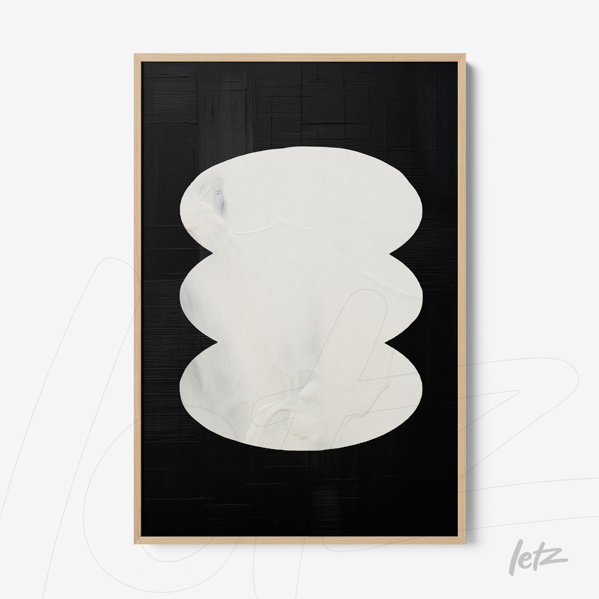 abstract wall art featuring white oval shapes on a black background with light frame