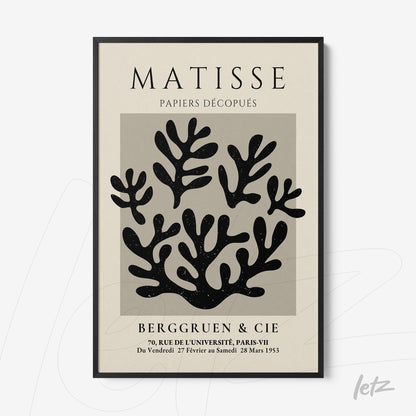 decorative wall art featuring cut-out leaf shapes in black on gray background with thin black frame