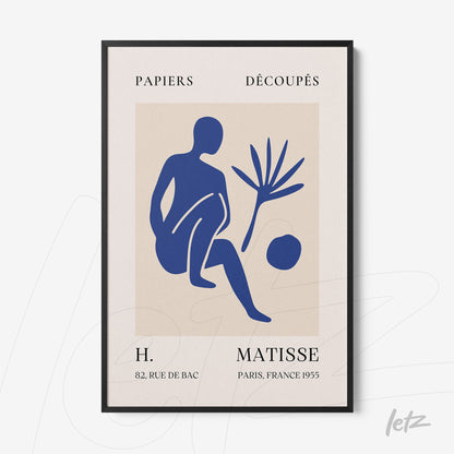 framed wall art featuring blue cut-out design of a seated figure alongside a plant