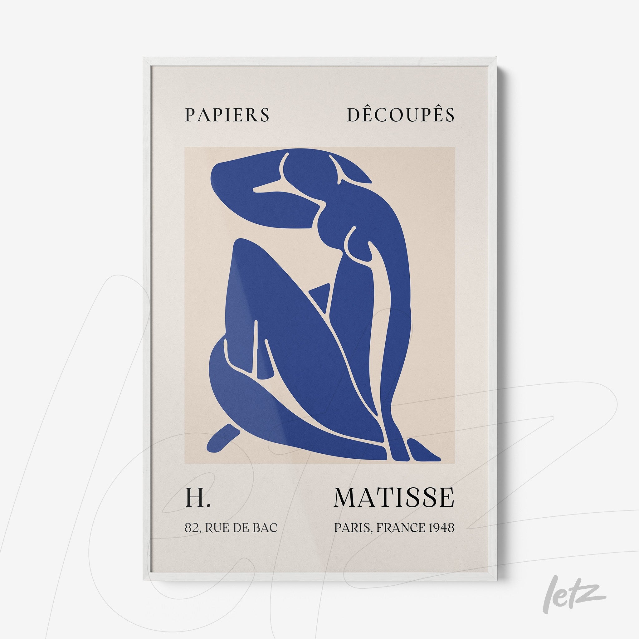 framed artwork of cut paper in blue depicting a seated female figure with a fine white frame and a beige background