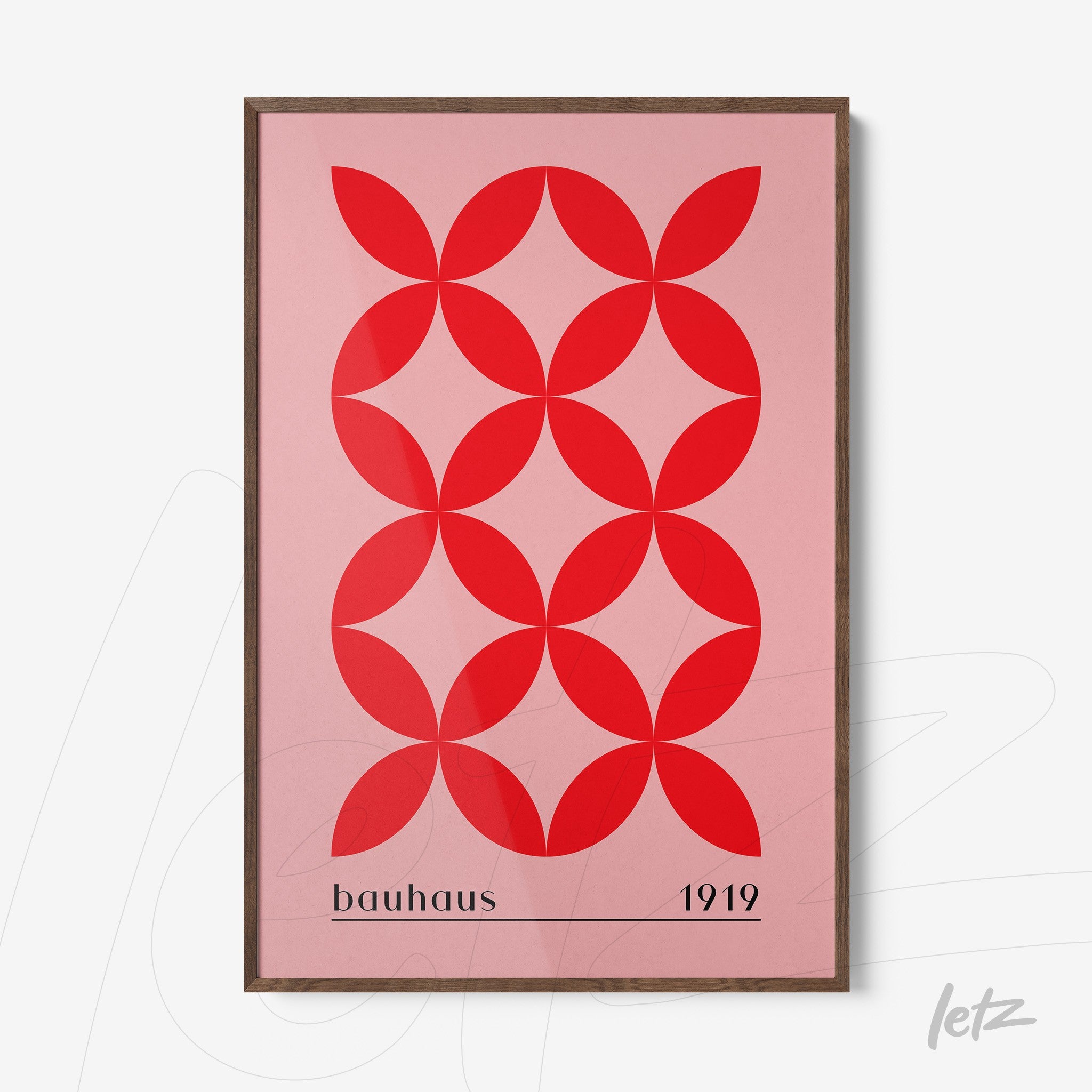 poster print with geometric design of red circles on a pink background in a wooden frame