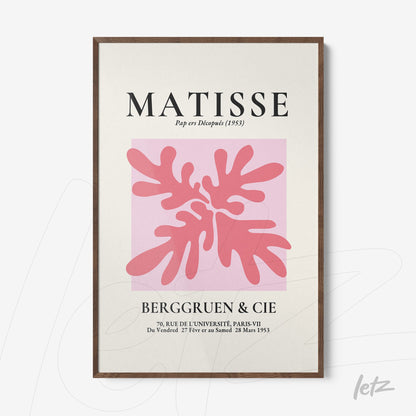 framed modern art piece featuring organic shapes in shades of pink on a light pink background with dark wood frame