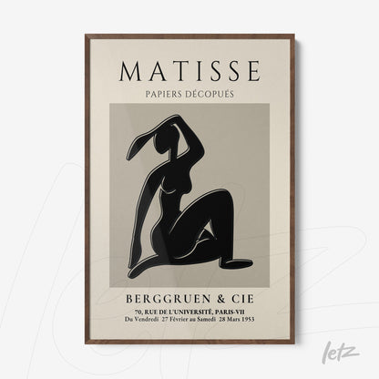framed modern art piece in black and white depicting a dancing female figure, light wood frame
