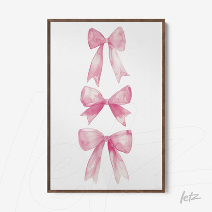 framed artwork of pink watercolor bows in light wood frame