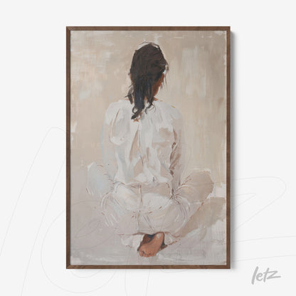 framed artwork of a seated female figure from behind, wearing white clothing and with loose hair, in a light wooden frame