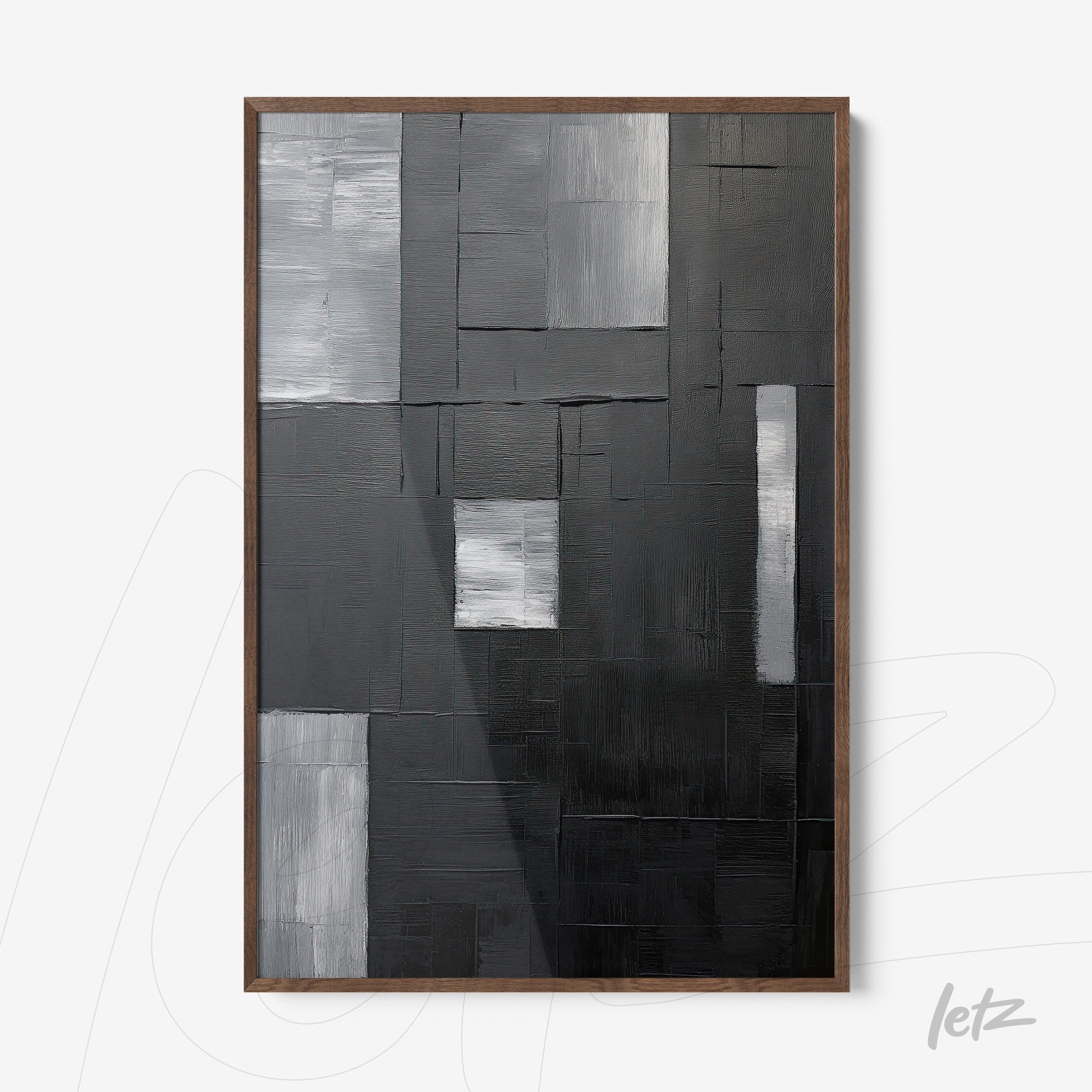 abstract wall art in shades of black, gray, and silver in a dark wood frame