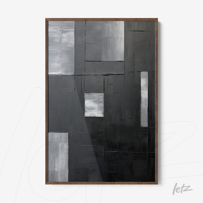 abstract wall art in shades of black, gray, and silver in a dark wood frame
