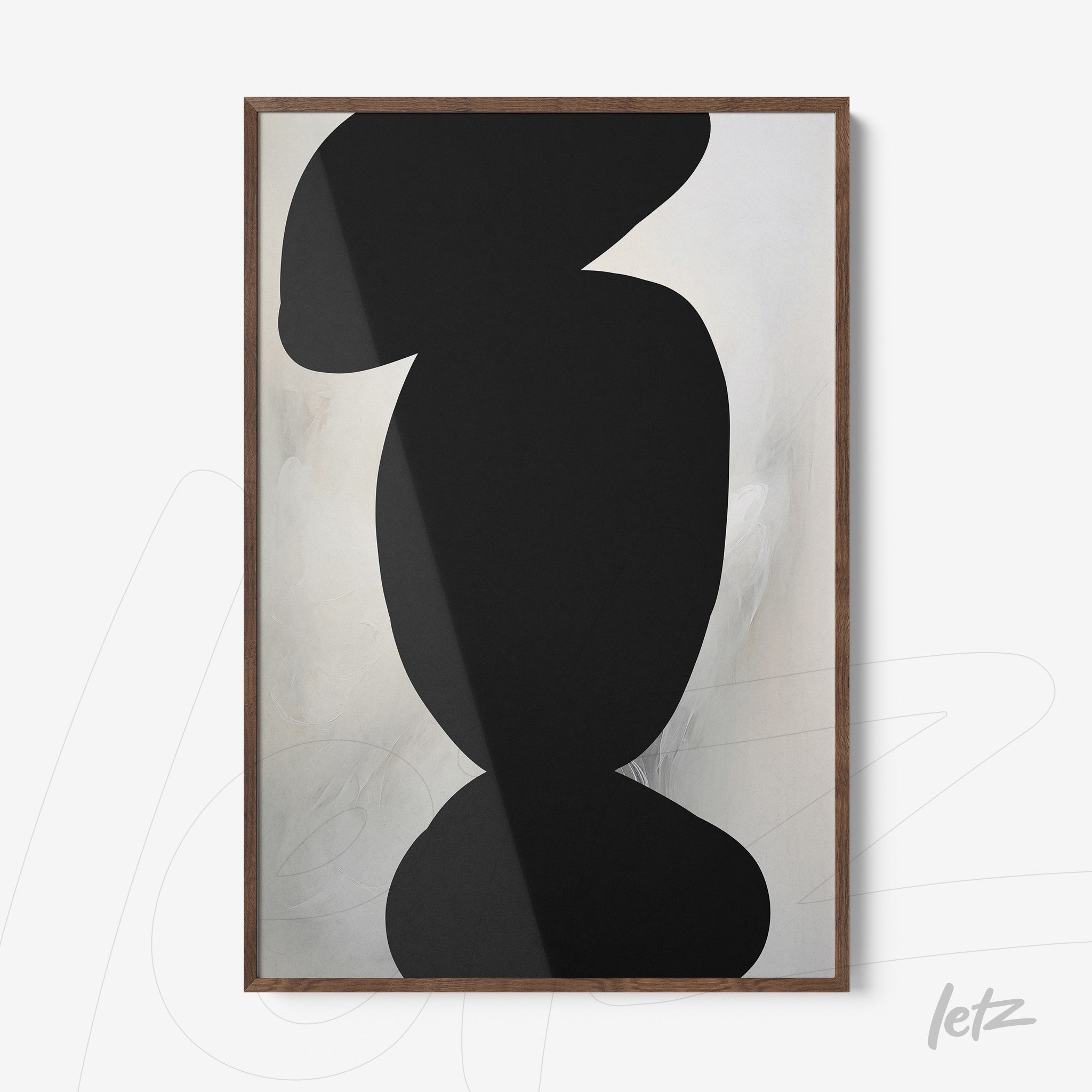 framed art with abstract black shapes on light background in light wood frame