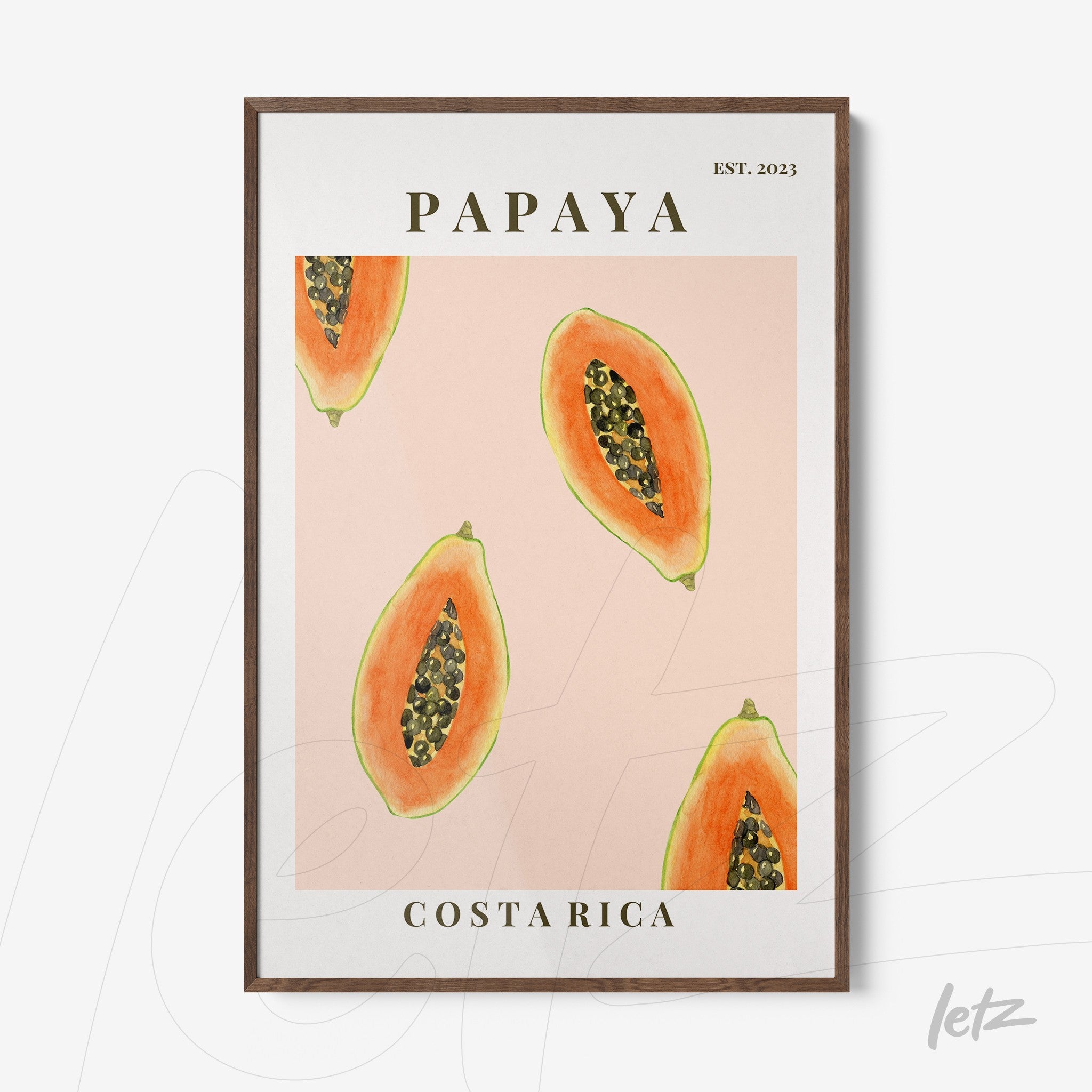 framed artwork featuring papaya slices on a pink background with dark wood frame