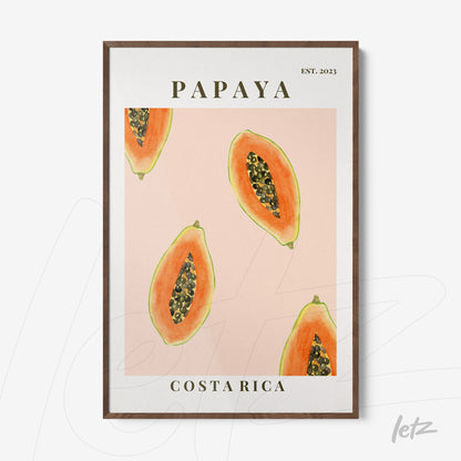 framed artwork featuring papaya slices on a pink background with dark wood frame
