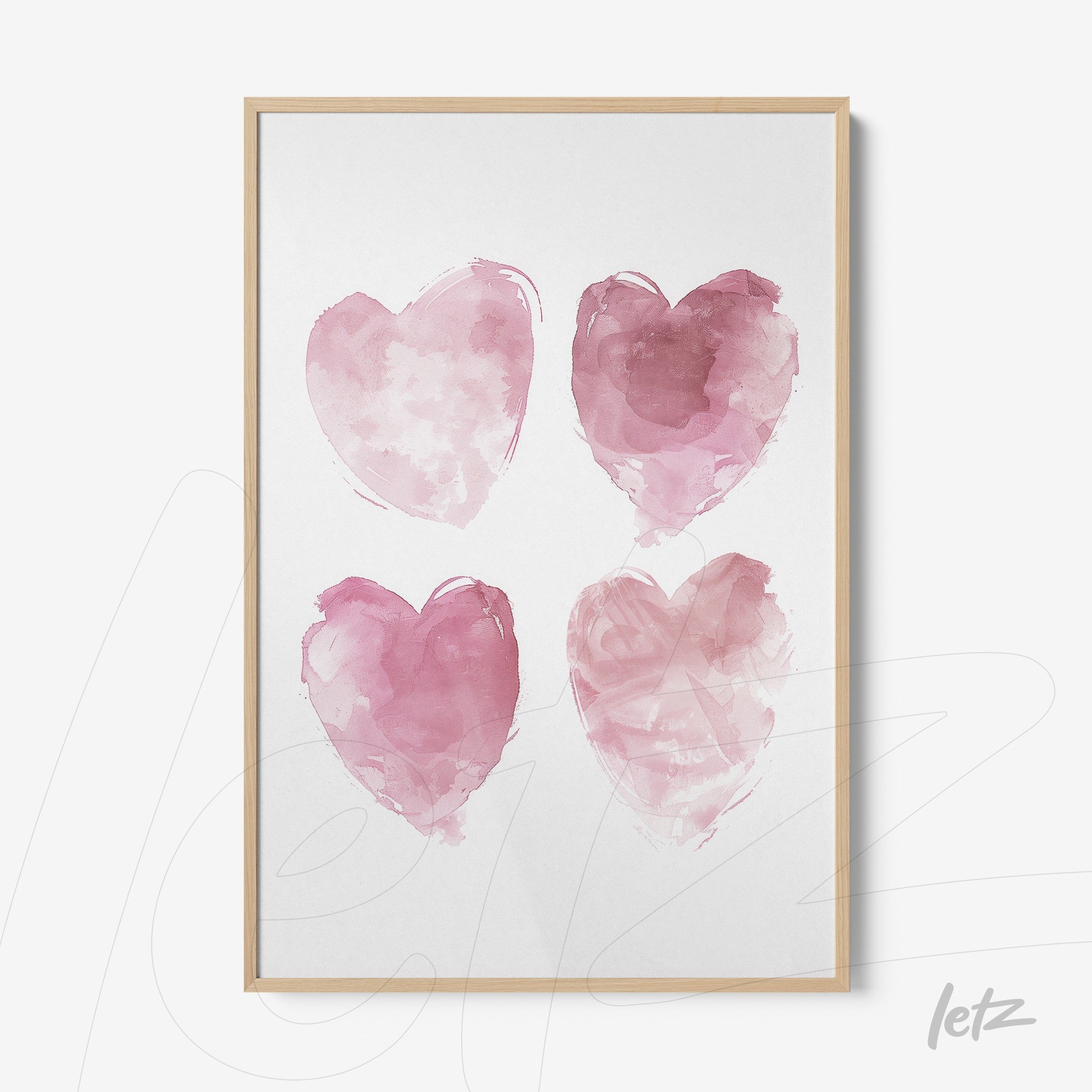 framed artwork featuring four watercolor hearts in shades of pink with a light wood frame