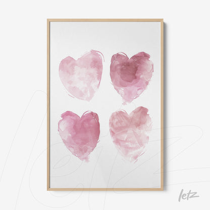 framed artwork featuring four watercolor hearts in shades of pink with a light wood frame