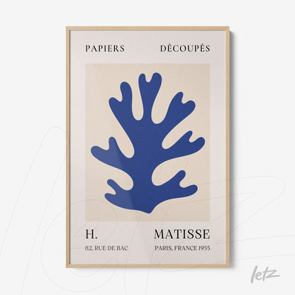 framed art print featuring blue paper cutouts on cream background with light wood frame