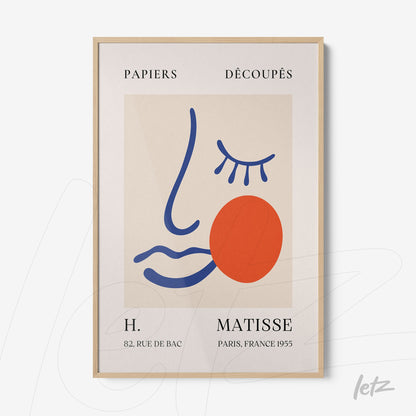 modern art framed piece featuring a stylized face in vibrant colors with a light wood frame