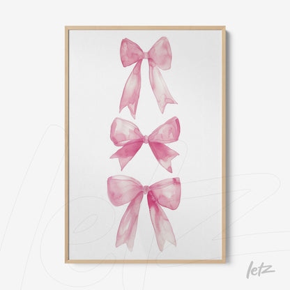 framed artwork featuring three pink watercolor bows with light wooden frame