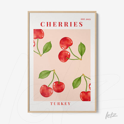 framed wall art featuring vibrant cherries on a pink background with light wood frame