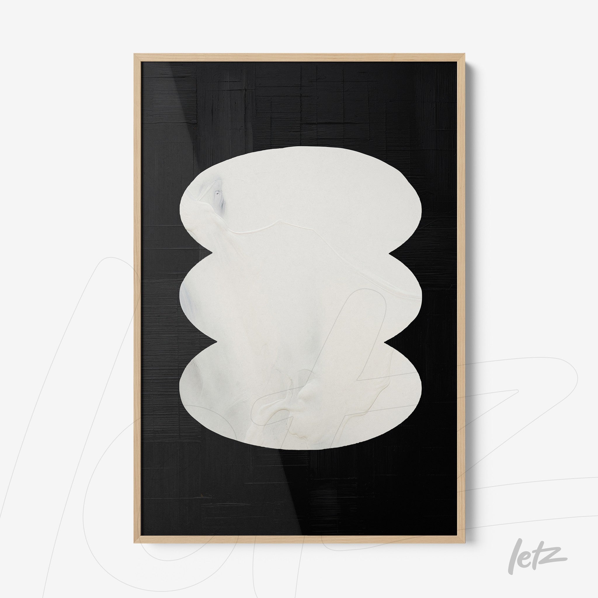 framed abstract wall art featuring white oval shapes on a black background with light wood frame