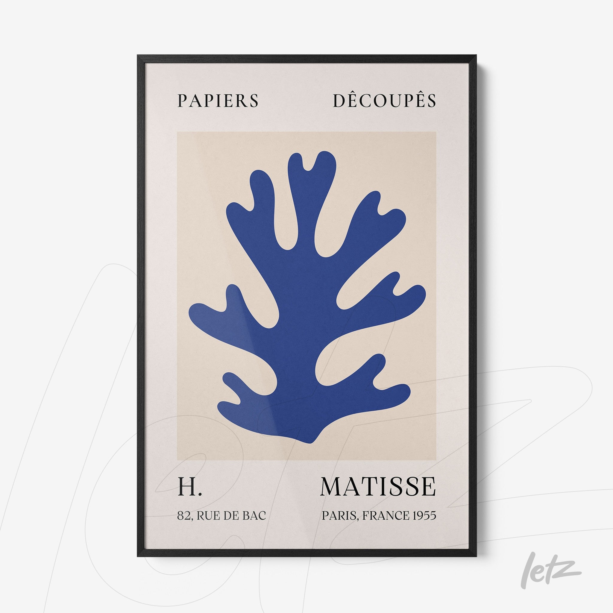 framed modern art featuring blue cut-out shapes resembling leaves with black frame