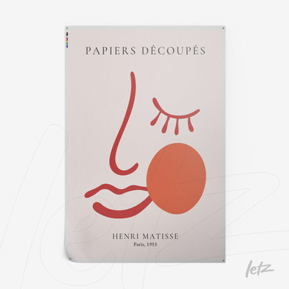 decorative wall art featuring minimalist stylized face design on light background with french text and red and orange lines